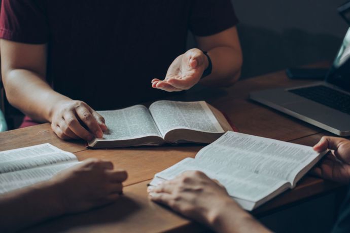 3 people around open bibles, studying