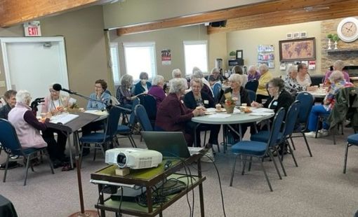 large group of ladies fellowshipping around tables