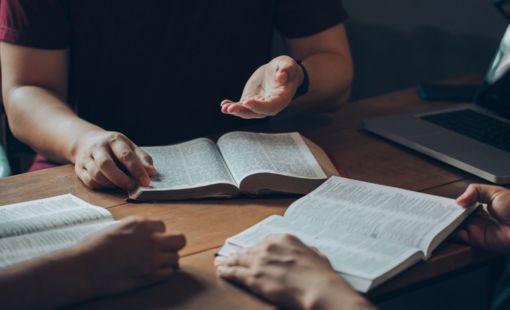 3 people with open bibles, studying