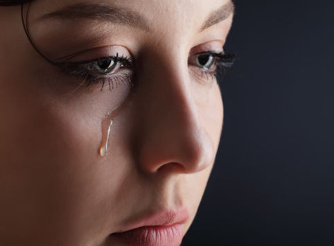 Close up of an individual's face with a tear running down their cheek
