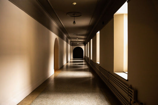 Hallway with light filtering in through multiple windows on one side