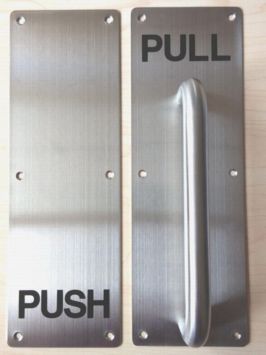 Silver door plate with the word PUSH and silver handle will word PULL